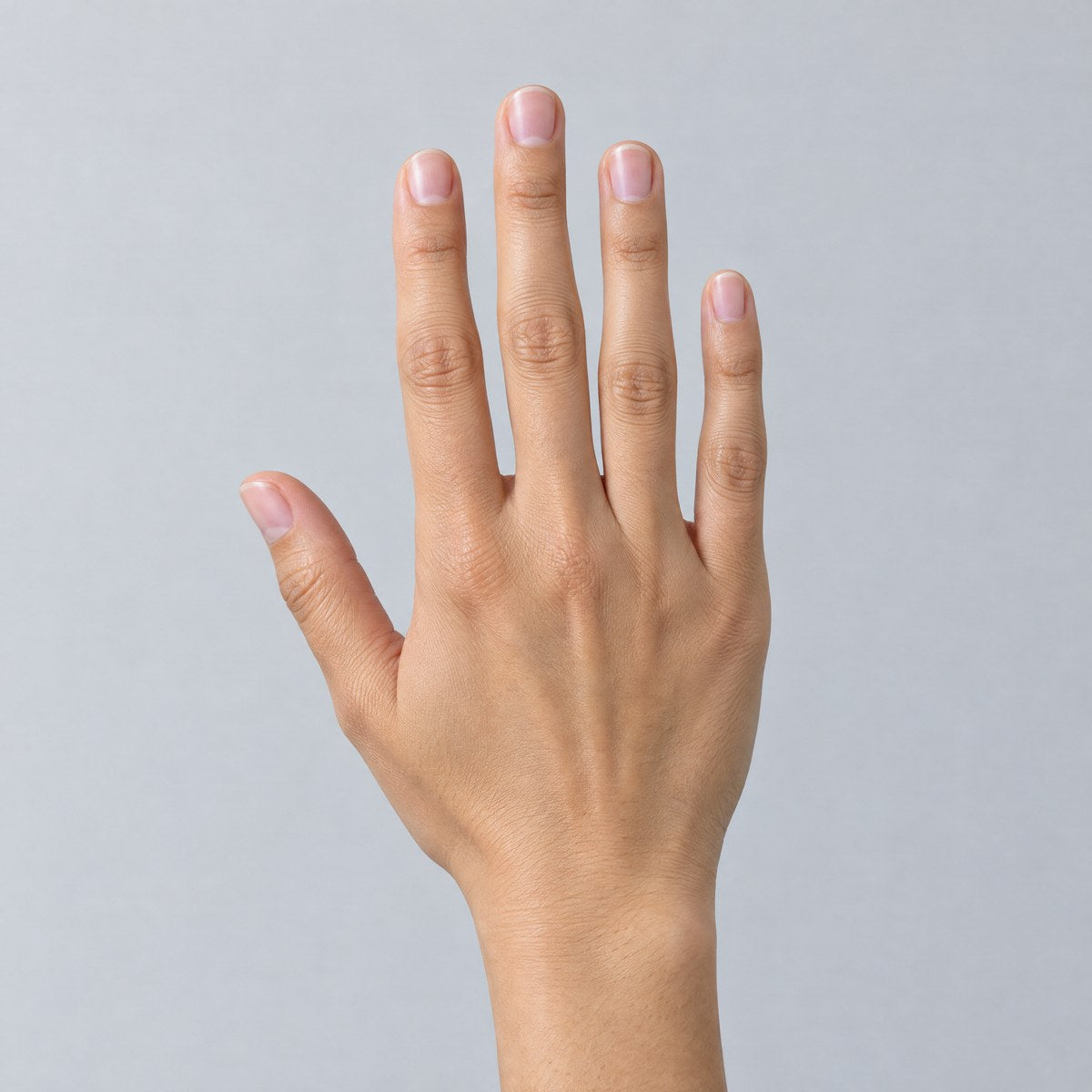 Hand with bare natural short nails before applying press-on nails